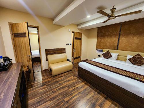 a hotel room with a bed and a chair at Arcadian Hotel in Gangtok