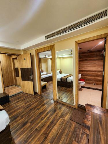 a room with a room with two beds and a mirror at Arcadian Hotel in Gangtok