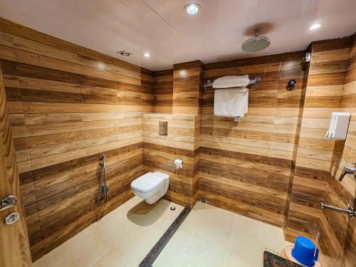 a bathroom with wooden walls and a toilet at Arcadian Hotel in Gangtok