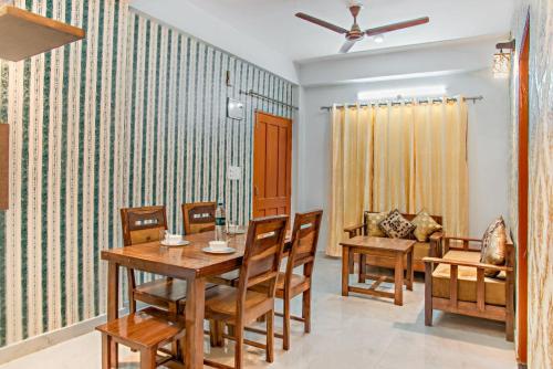 a dining room with a table and chairs at Exotic Stays I The Pine Trails I Serviced Apartments I Toy Train View I Best Seller I Guaranteed Best Price I Kasauli in Kasauli
