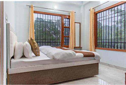 a bed in a room with a large window at Exotic Stays I The Pine Trails I Serviced Apartments I Toy Train View I Best Seller I Guaranteed Best Price I Kasauli in Kasauli