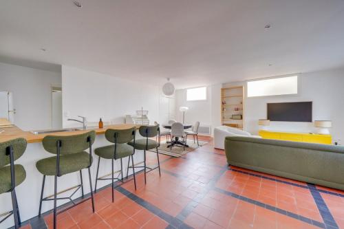 Cette chambre dispose d'un bar, de chaises et d'une télévision. dans l'établissement Centre du Moulleau -Apt Voile au Vent- 5 minutes à pied de la plage, à Arcachon