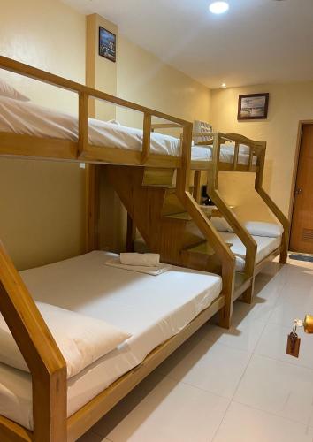 a bunk bed room with three bunk beds in it at Susada's Inn in Oslob