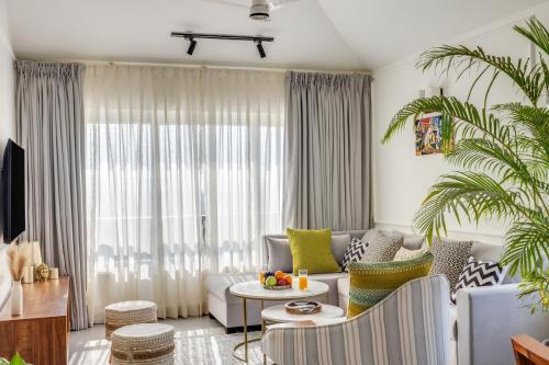 a living room with a couch and a table at Casa De Solares- New 2BHK Apartment with Pool Candolim in Pilerne
