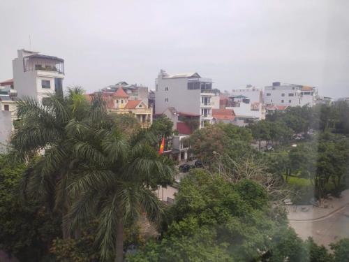 a city with a palm tree and buildings at Light Hotel Ha Noi in Hanoi