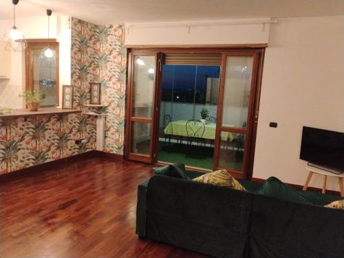 a living room with a couch and a view of a bedroom at Maison Laurier in Fiumicino Airport