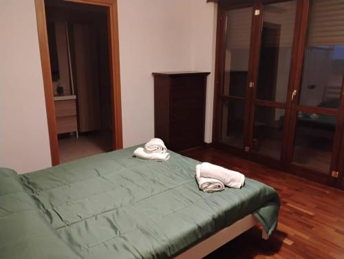 a bedroom with a green bed with towels on it at Maison Laurier in Fiumicino Airport