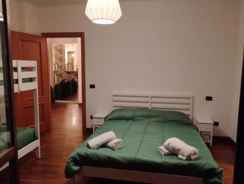 a bedroom with a green bed with two pillows on it at Maison Laurier in Fiumicino Airport