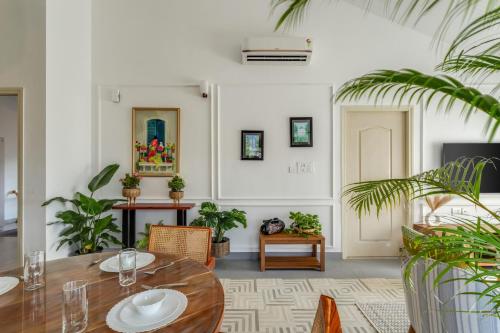 a dining room with a table and some plants at Casa De Solares- New 2BHK Apartment with Pool Candolim in Pilerne