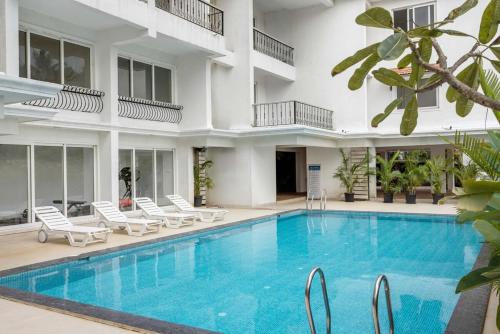 a swimming pool in front of a building at Casa De Solares- New 2BHK Apartment with Pool Candolim in Pilerne