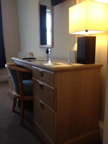 a desk with a lamp and a chair in a room at Northallerton Motel in Northallerton