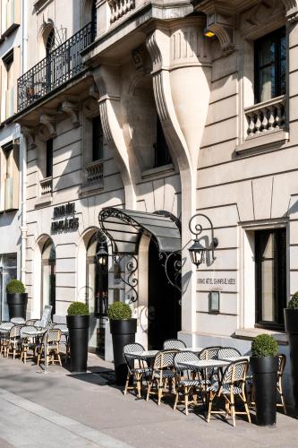 une rangée de tables et de chaises devant un bâtiment dans l'établissement Grand Hôtel Champs-Elysées, à Paris