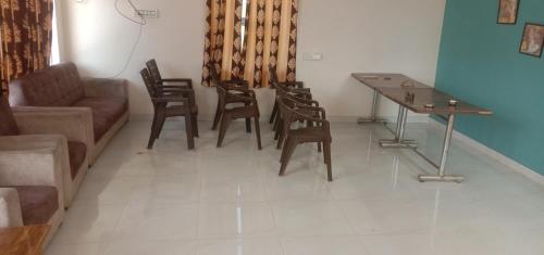 a living room with a couch and a table and chairs at Ranthambore Bagh niwas in Khilchipur