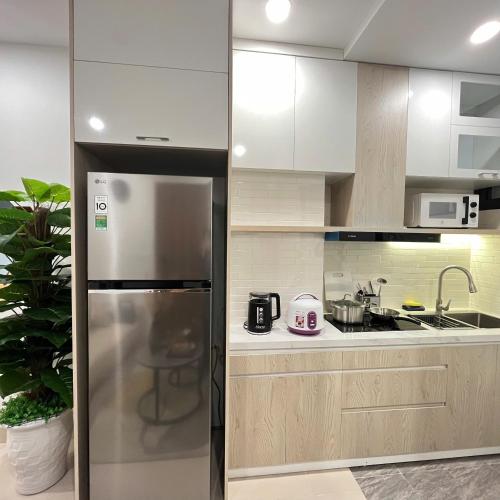 a kitchen with a refrigerator and a sink at The Literature'N Central Hotel and Travel Ha Noi 177 in Hanoi