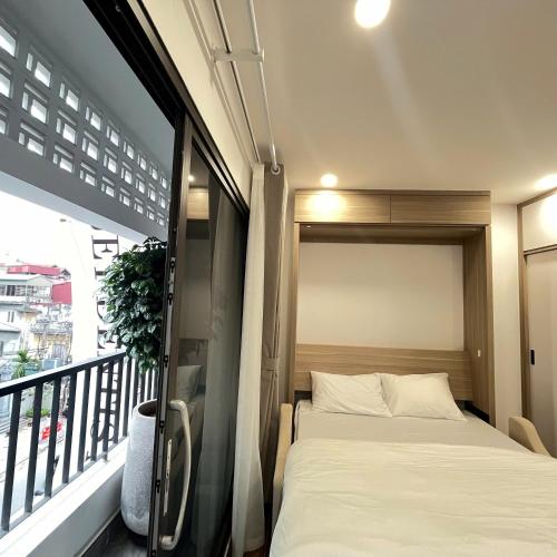 a small bedroom with a bed on a balcony at The Literature'N Central Hotel and Travel Ha Noi 177 in Hanoi