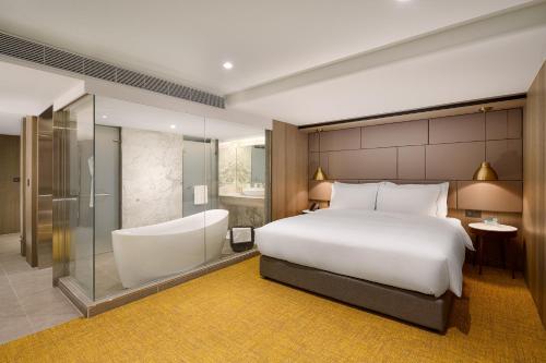 a hotel room with a bed and a bath tub at JAI Château Hotels & Hostels in Tainan