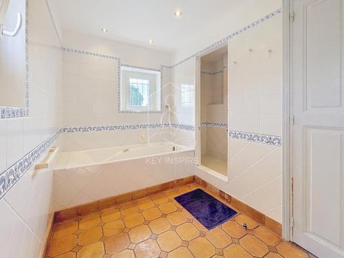 a large bathroom with a tub and a shower at Le Mas Valou, villa en pierre dans les hauteurs de Fayence in Tourrettes