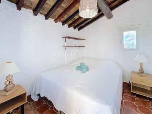a bedroom with a white bed and two lamps at Le Mas Valou, villa en pierre dans les hauteurs de Fayence in Tourrettes
