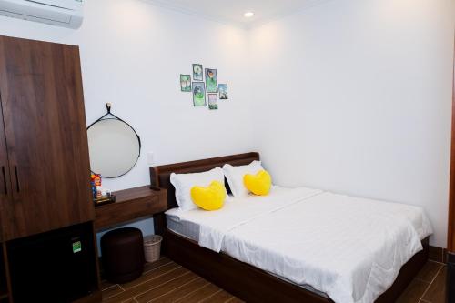 a bedroom with a bed with two yellow pillows at Suka Hotel in Tây Ninh