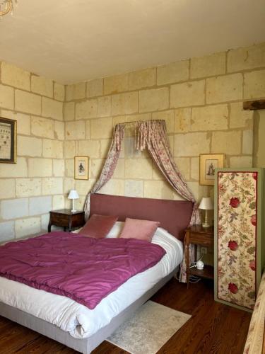 - une chambre avec un lit violet dans l'établissement Chateau de la Boussiniere, à Gennes