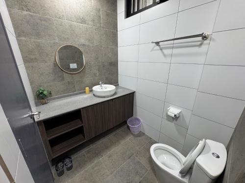 a bathroom with a sink and a toilet and a mirror at Podium Home2 for 7pax at AEON Mall Kuching in Kuching
