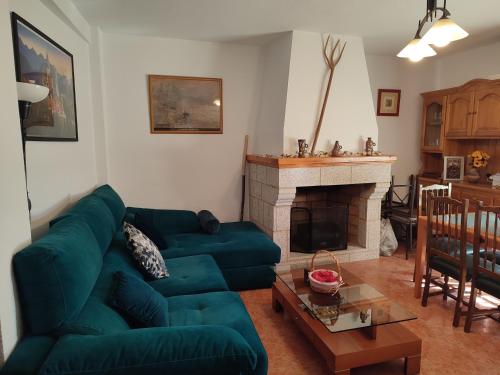un soggiorno con divano verde e camino di Casa Rogelio Valverde a Valverde de la Vera