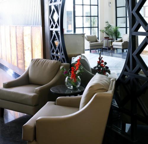 a living room with couches and a table with flowers at Avari Boutique Gujranwala in Fattu Mand