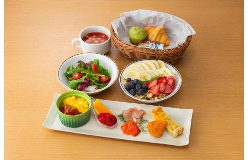 a table with plates of food and bowls of food at PROSTYLE RYOKAN TOKYO ASAKUSA in Tokyo