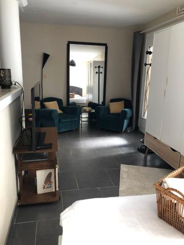 - un salon avec des chaises bleues et un miroir dans l'établissement La rencontre, à Ars-sur-Formans