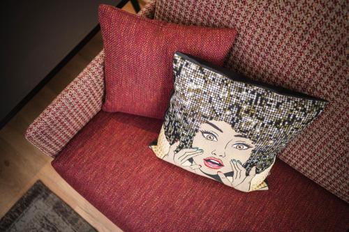 a pillow with a picture of a woman sitting on a chair at Pension Haus Tirol in Laion