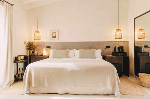a white bedroom with a large white bed with pillows at Finca Serena Mallorca, Small Luxury Hotels in Montuiri