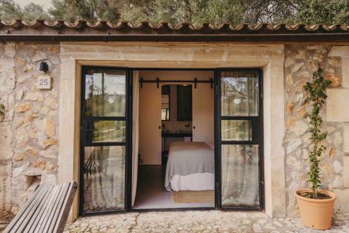 a room with sliding glass doors with a bed inside at Finca Serena Mallorca, Small Luxury Hotels in Montuiri