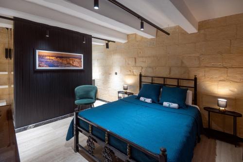 ビルグにあるBirgu Boutique Stay Private Hot Tub & Cinemaのベッドルーム(青いベッド1台、緑の椅子付)
