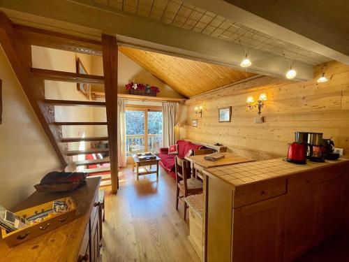 une cuisine et un salon dans une cabane en rondins dans l'établissement Le Doux Refuge, à Les Allues