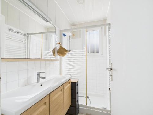 une salle de bain blanche avec un lavabo et une douche dans l'établissement Ty Gwen Mar - maison les pieds dans l'eau pour 6, à Plouguerneau