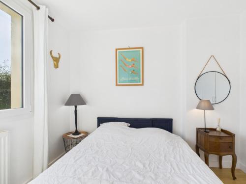 une chambre blanche avec un lit et un miroir dans l'établissement Ty Gwen Mar - maison les pieds dans l'eau pour 6, à Plouguerneau