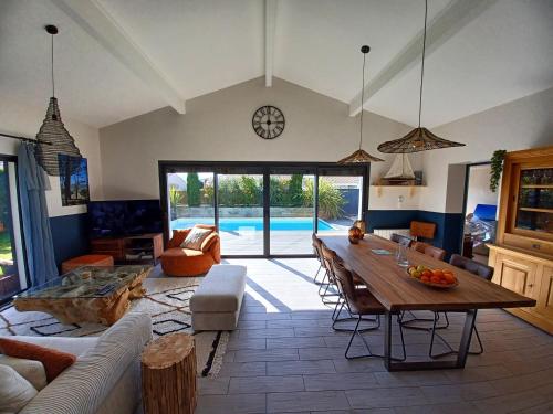 un salon avec une table et une piscine dans l'établissement Belle Villa bassin d'Arcachon, à La Teste-de-Buch