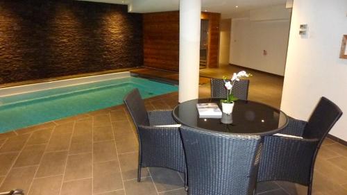 a pool in the middle of a room with a table and chairs at Hotel Mont.Lac in Champex