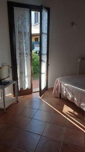 a bedroom with a bed and an open door at Oleandro Cottage with garden in La Cinquantina
