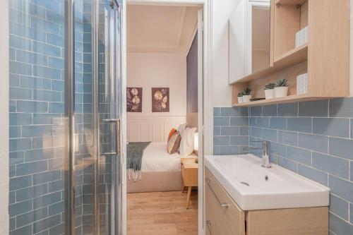 La salle de bains est pourvue d'un lavabo, d'une douche et d'un lit. dans l'établissement Studio Douillet pour 2 au Cœur de Montmartre-II, à Paris