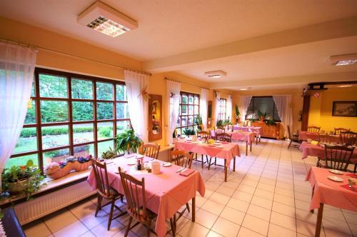 ein Restaurant mit Tischen und Stühlen und einem großen Fenster in der Unterkunft Hotel Weidenau in Bad Orb