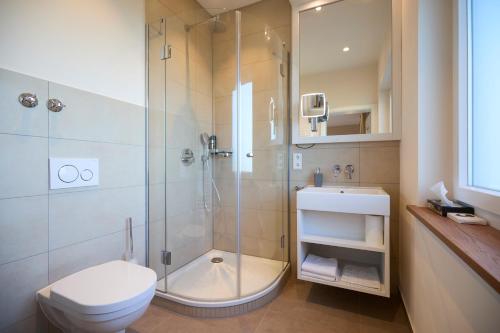 a bathroom with a shower and a toilet and a sink at Bundt's Hotel & Gartenrestaurant in Hamburg