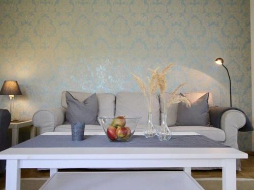 a living room with a couch and a table with fruit on it at Komfort-Ferienwohnung am See in Bodman-Ludwigshafen