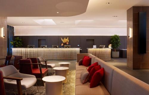 a lobby with a waiting room with red pillows at Holiday Inn Express Melbourne Southbank by IHG in Melbourne