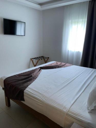 a bedroom with a large white bed with a window at Coral Strand Smart Choice in Beau Vallon