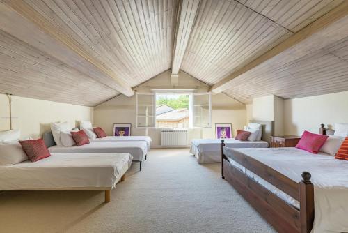 Cette grande chambre comprend 4 lits et une fenêtre. dans l'établissement Demeure en pierre au cœur des vignobles de Bordeaux, à Saint-Germain-de-la-Rivière