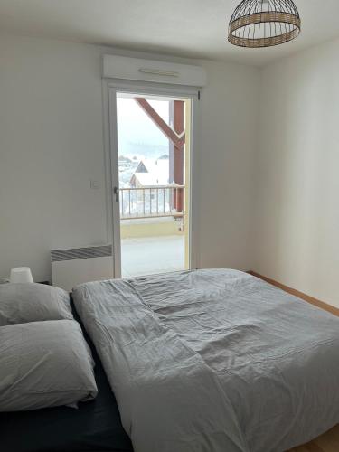 une chambre avec un lit et une grande fenêtre dans l'établissement O'fil du Doubs Apartment, à Labergement-Sainte-Marie