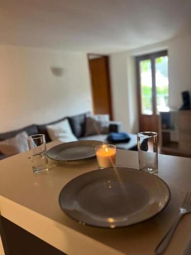 - une table avec deux assiettes et deux bougies dans l'établissement Appartement centrale, à Tende