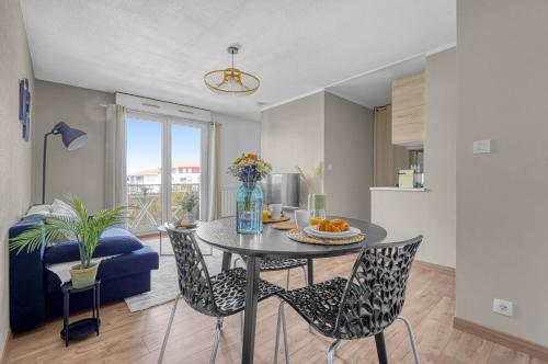 un salon avec une table et des chaises et une cuisine dans l'établissement Spacious Apartment Blagnac Parking-Tram-Airport, à Blagnac