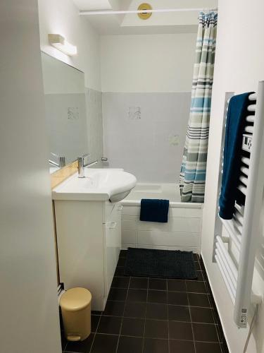 une salle de bain blanche avec un lavabo et une baignoire dans l'établissement Trestraou 2P Apartment with a small sea view, à Perros-Guirec